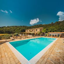 Historic stone farmhouse surrounded by lush greenery near Cefalù, Sicily