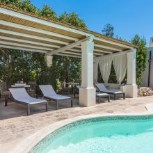 Poolside relaxation area surrounded by plants at holiday accommodation in Salento