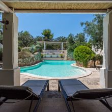 Swimming pool surrounded by Mediterranean greenery at holiday apartments in Salento, Puglia
