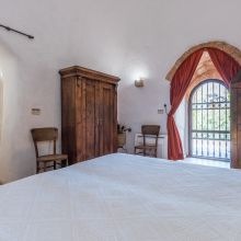 Bedroom with rustic details in a traditional holiday house in Puglia