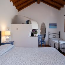 Rustic guest bedroom with wooden furniture and warm Mediterranean colours in Sicily Rustic guest bedroom with wooden furniture and warm Mediterranean colours in Sicily
