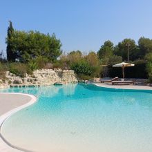 Swimming pool surrounded by palm trees and Mediterranean vegetation Swimming pool surrounded by palm trees and Mediterranean vegetation in Salento