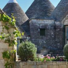 Traditional Apulian trulli surrounded by greenery at the resort