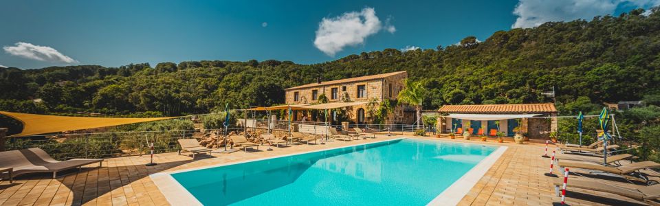 Historic stone farmhouse surrounded by lush greenery near Cefalù, Sicily