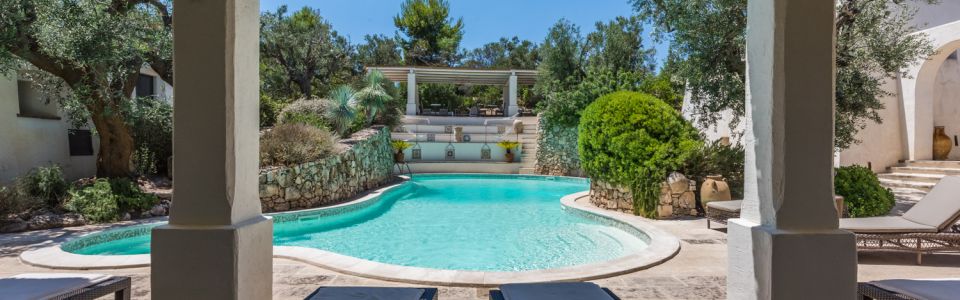 Swimming pool surrounded by Mediterranean greenery at holiday apartments in Salento, Puglia