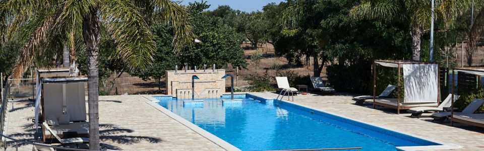 A cool blue pause beneath the southern Italian sun Swimming pool at an Apulian countryside farmhouse surrounded by greenery