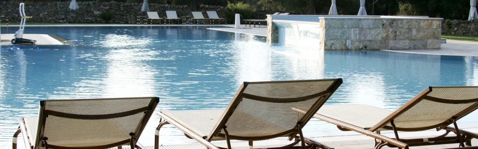 Large swimming pool surrounded by olive trees at a historic masseria in Salento