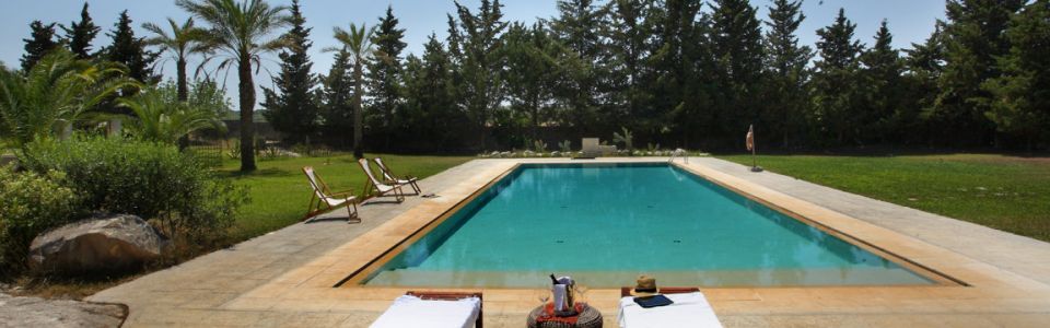 A refreshing escape in the Apulian countryside Large outdoor swimming pool surrounded by green lawns in Salento